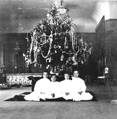 Grand Duchesses Olga, Tatiana, Maria and Anastasia Romanov posing in front of a Christmas tree.