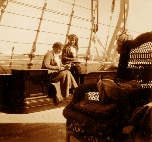 Grand Duchess Olga reading on deck of the imperial yacht The Standart, with Grand Duchess Anastasia standing next to her.
