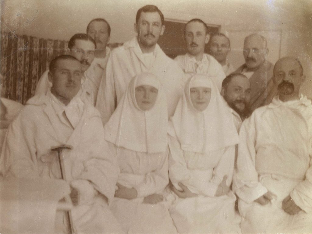 Sister Olga Romanov and Sister Tatiana Romanov posing with the wounded at their Tsarskoe Selo infirmary in 1915. 