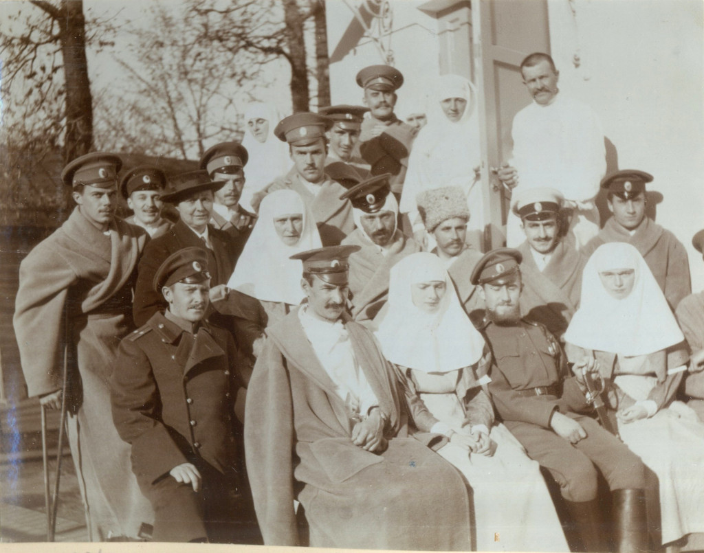 Sister Alexandra Romanov with Sister Olga Romanov and Sister Tatiana Romanov posing with wounded patients at their infirmary. 