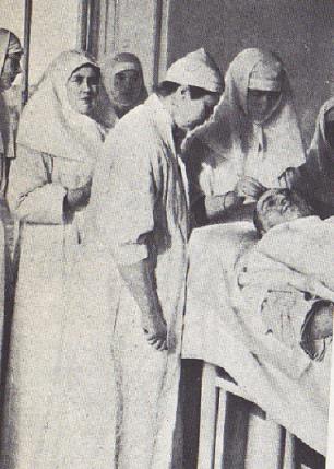 Standing on the lef is: “Anya” Vyrubova, a Romanov family friend, in her nurse uniform. 